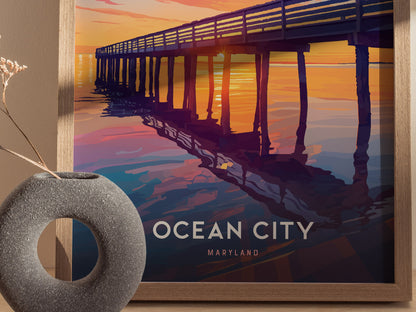 A framed poster depicts a boardwalk pier at sunset, with vibrant orange and purple hues reflecting on the water. The words OCEAN CITY MARYLAND are prominently displayed below.