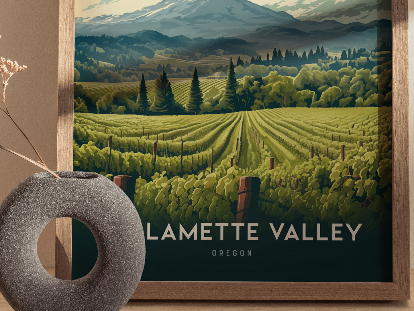 A framed illustration of Oregons Willamette Valley features lush vineyards, rolling hills, and distant mountains, set against a wooden frame and a circular stone vase.