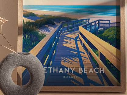A framed poster of Bethany Beach, Delaware, depicts a sunlit wooden boardwalk leading through coastal dunes toward the ocean. A textured circular vase with dried flowers sits nearby.