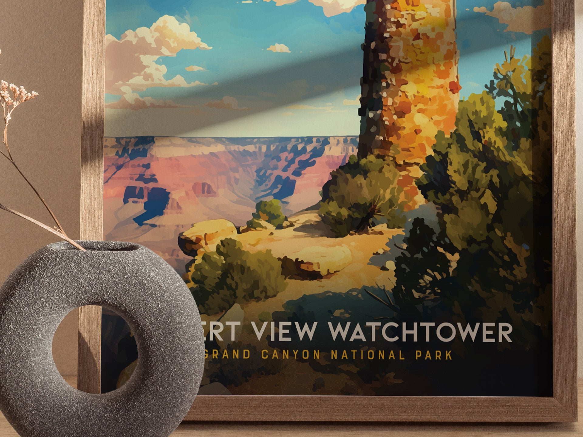 A framed poster depicts the Desert View Watchtower against a vibrant Grand Canyon landscape, with a textured gray vase in the foreground.