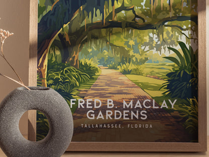 Framed illustration of Alfred B. Maclay Gardens features a winding brick path under moss-draped trees. A round, textured vase with dried flowers is placed in the foreground.