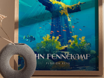 A colorful poster depicts an underwater scene with a statue, vibrant corals, and fish. A round, textured vase with dried flowers sits in front of the artwork.