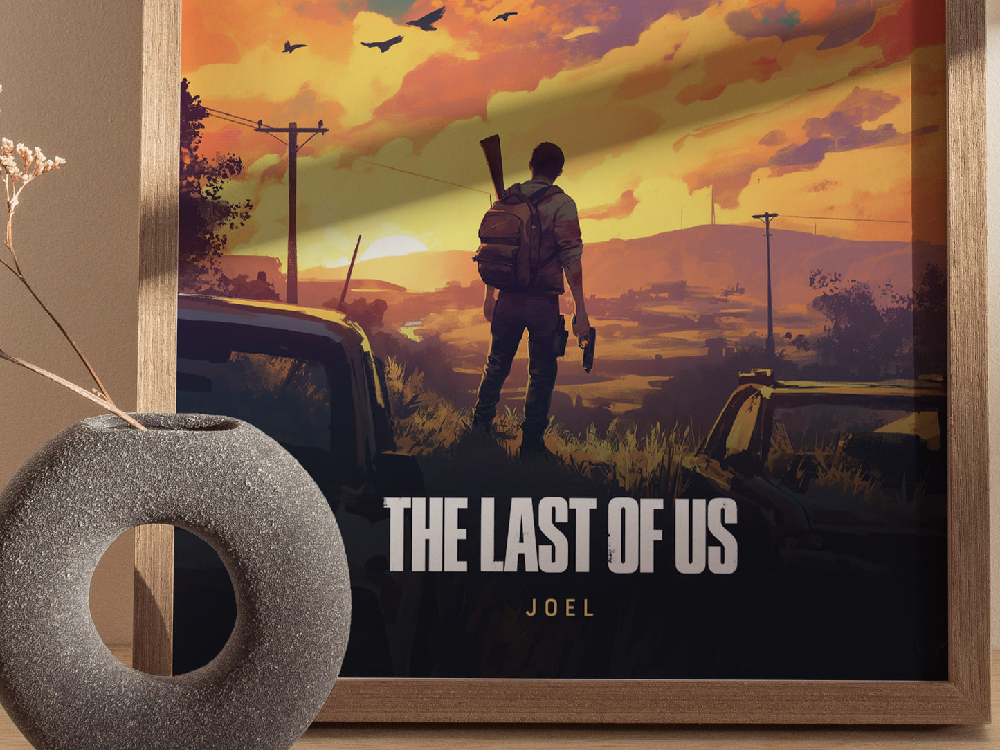 A framed poster of The Last of Us shows a man standing with a rifle, silhouetted against a vibrant sunset sky with birds. A decorative vase is in the foreground.