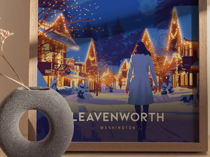 A framed poster depicts a person walking through a snowy village adorned with festive lights at night, with the words Leavenworth Washington visible below. A textured vase sits nearby.