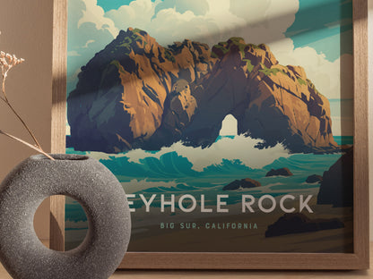 A framed poster of Keyhole Rock at Big Sur, California, features rugged cliffs with a natural archway, surrounded by ocean waves under a cloudy sky. In the foreground, a textured vase with dried flowers complements the artwork.