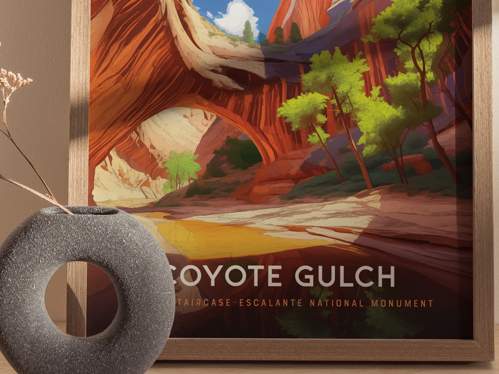 A framed poster of Coyote Gulch shows vibrant red canyon walls and green trees, with a modern vase in the foreground. The text reads Coyote Gulch, Escalante National Monument.