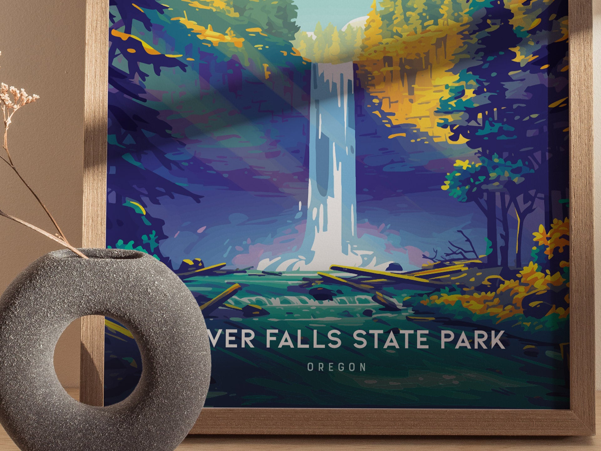 A colorful poster of Silver Falls State Park featuring a cascading waterfall surrounded by vibrant trees. A round, textured stone vase with dry branches is in the foreground.