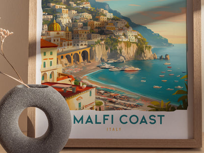A framed Amalfi Coast travel print showcases colorful cliffside villages above a turquoise sea, with a textured gray vase in the foreground.