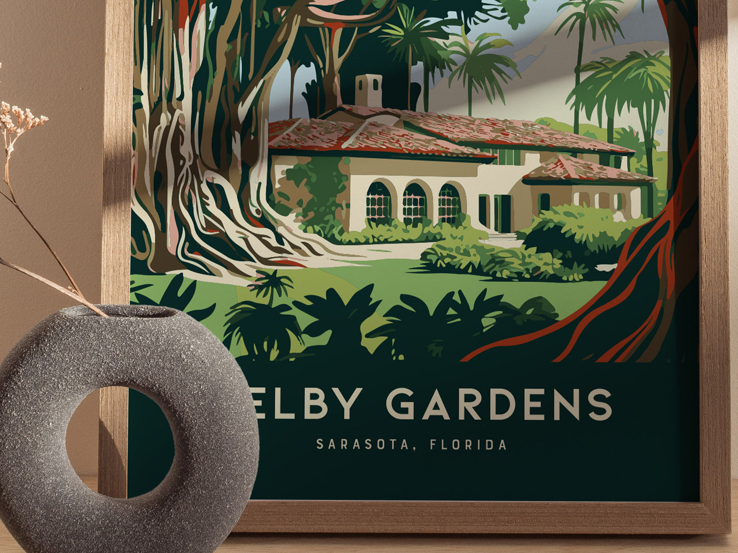 A framed poster features a lush botanical scene with a Mediterranean-style building surrounded by tropical plants, labeled Selby Gardens, Sarasota, Florida. A textured gray vase is in the foreground.