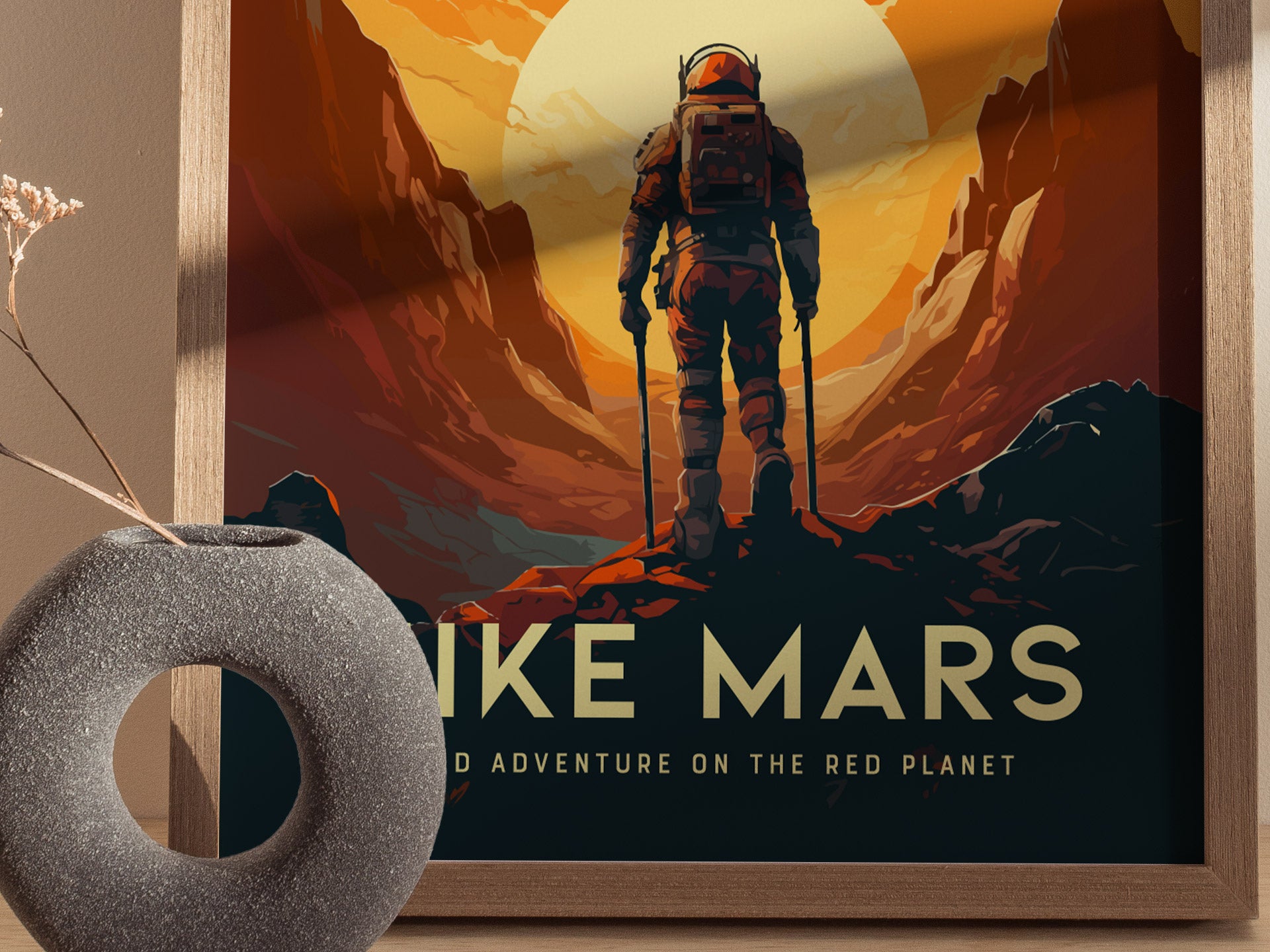 A framed poster depicts an astronaut standing on Martian terrain with stylized cliffs and a large sun, accompanied by the text HIKE MARS. A textured gray vase sits nearby.