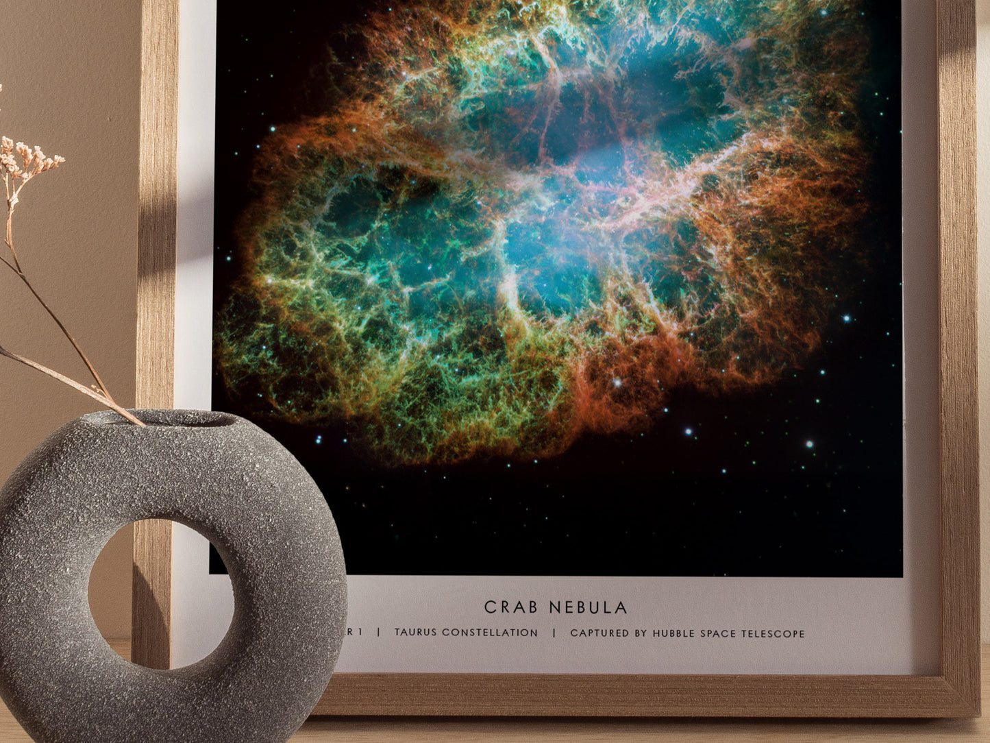 Framed print of the Crab Nebula with a decorative object on a table.
