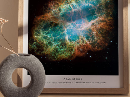 Framed print of the Crab Nebula with a decorative object on a table.