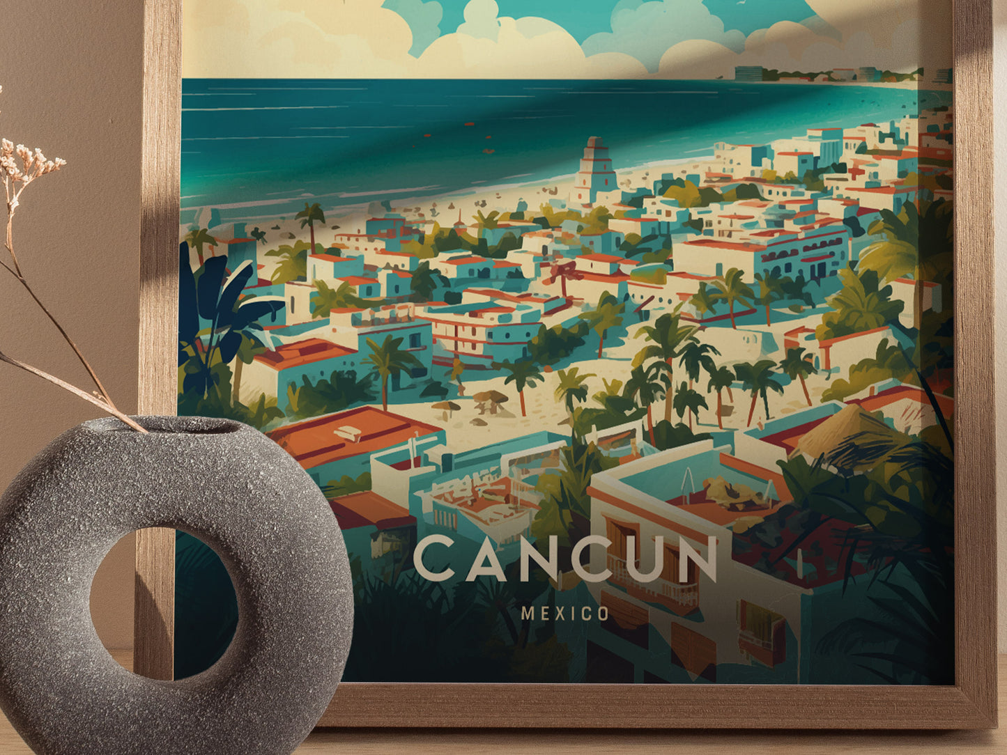 A vibrant poster depicting a coastal view of Cancun, Mexico, with colorful buildings, lush palm trees, and turquoise waters, framed in wood. A round stone vase sits nearby.