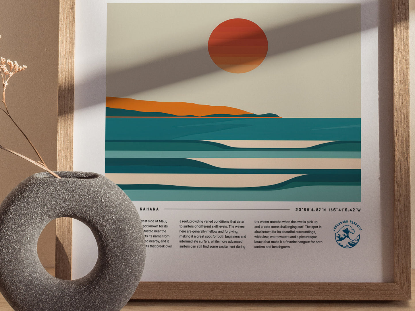 A minimalist art print of a sunset over teal ocean waves with an orange horizon, framed and placed next to a round, textured vase on a wooden surface.