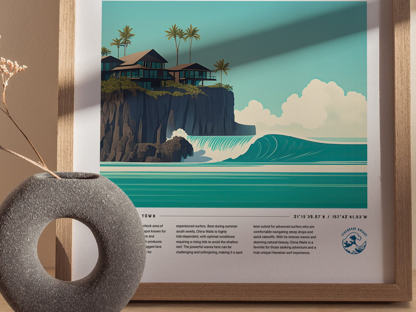 A framed poster featuring a stylized illustration of Oahus China Walls, with turquoise waves, rocky cliffs, palm trees, and coastal homes. A decorative vase is placed in front.