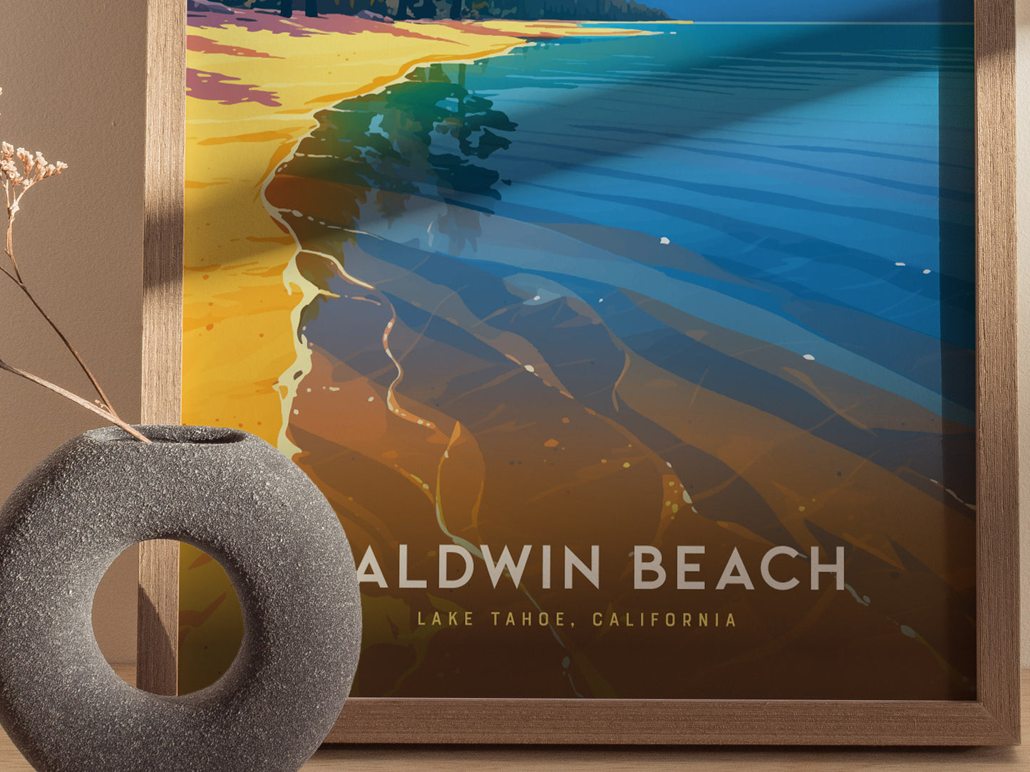 A framed artwork of Baldwin Beach, Lake Tahoe, features vibrant colors depicting the shoreline and clear waters. A circular stone vase with dried flowers is placed nearby.