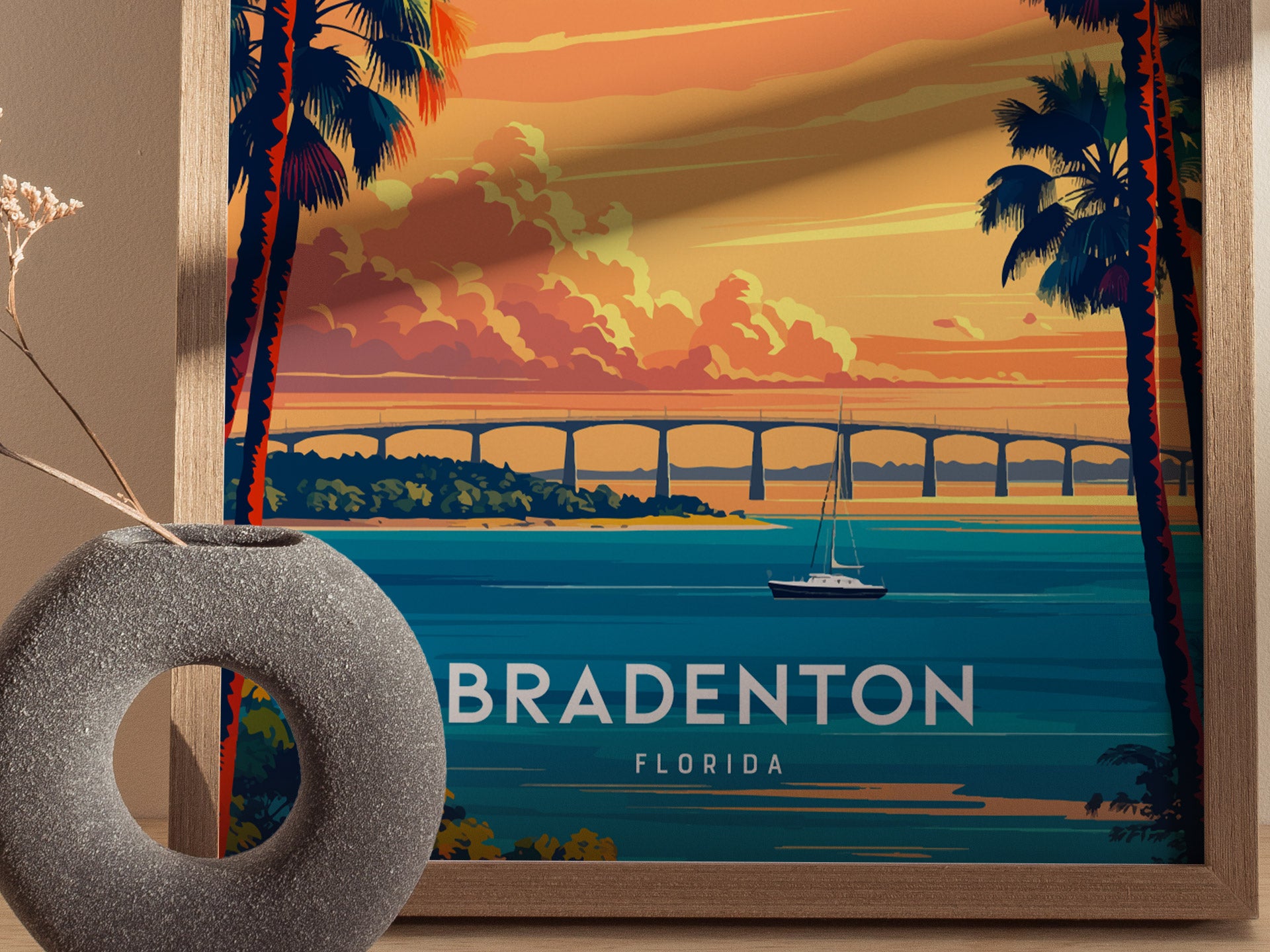 Framed artwork of Bradenton, Florida with a sunset over water and bridge.