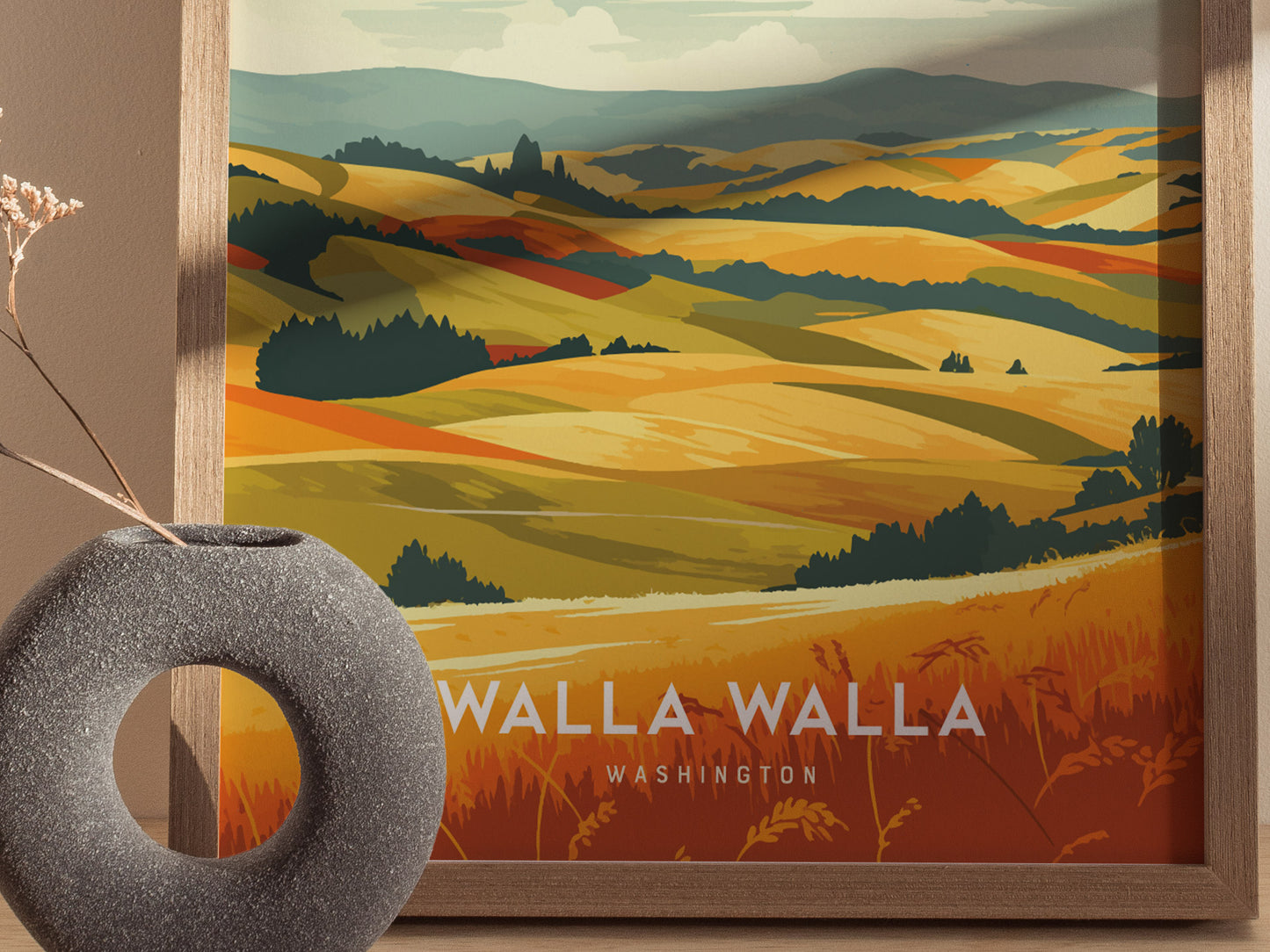 A framed poster titled Walla Walla Washington depicts rolling hills and vineyards in warm tones, with a textured vase and dried plant in the foreground.