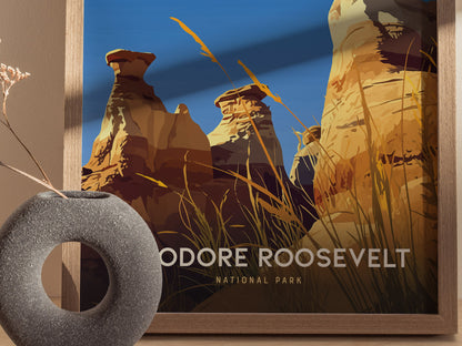 A framed poster featuring the dramatic hoodoos of Theodore Roosevelt National Park, with vibrant blue skies and golden grasses. A textured, circular stone vase sits nearby.