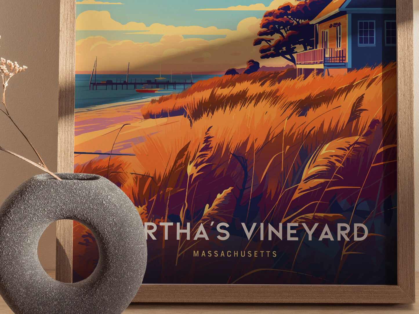 A framed poster of Martha’s Vineyard features vibrant orange and blue coastal scenery with a house, pier, and beach grasses.