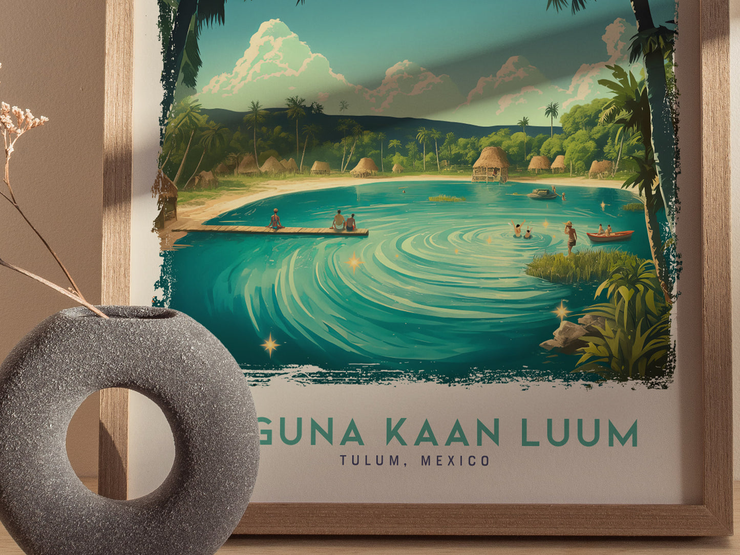 A framed poster of Laguna Kaan Luum in Tulum, Mexico, featuring a turquoise lagoon with a wooden pier, surrounded by lush greenery and huts.