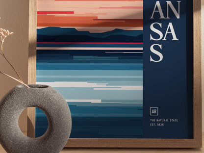 A minimalist poster with abstract horizontal stripes in warm and cool tones, partially obscured text reading ANSAS, and a decorative stone vase on the side.