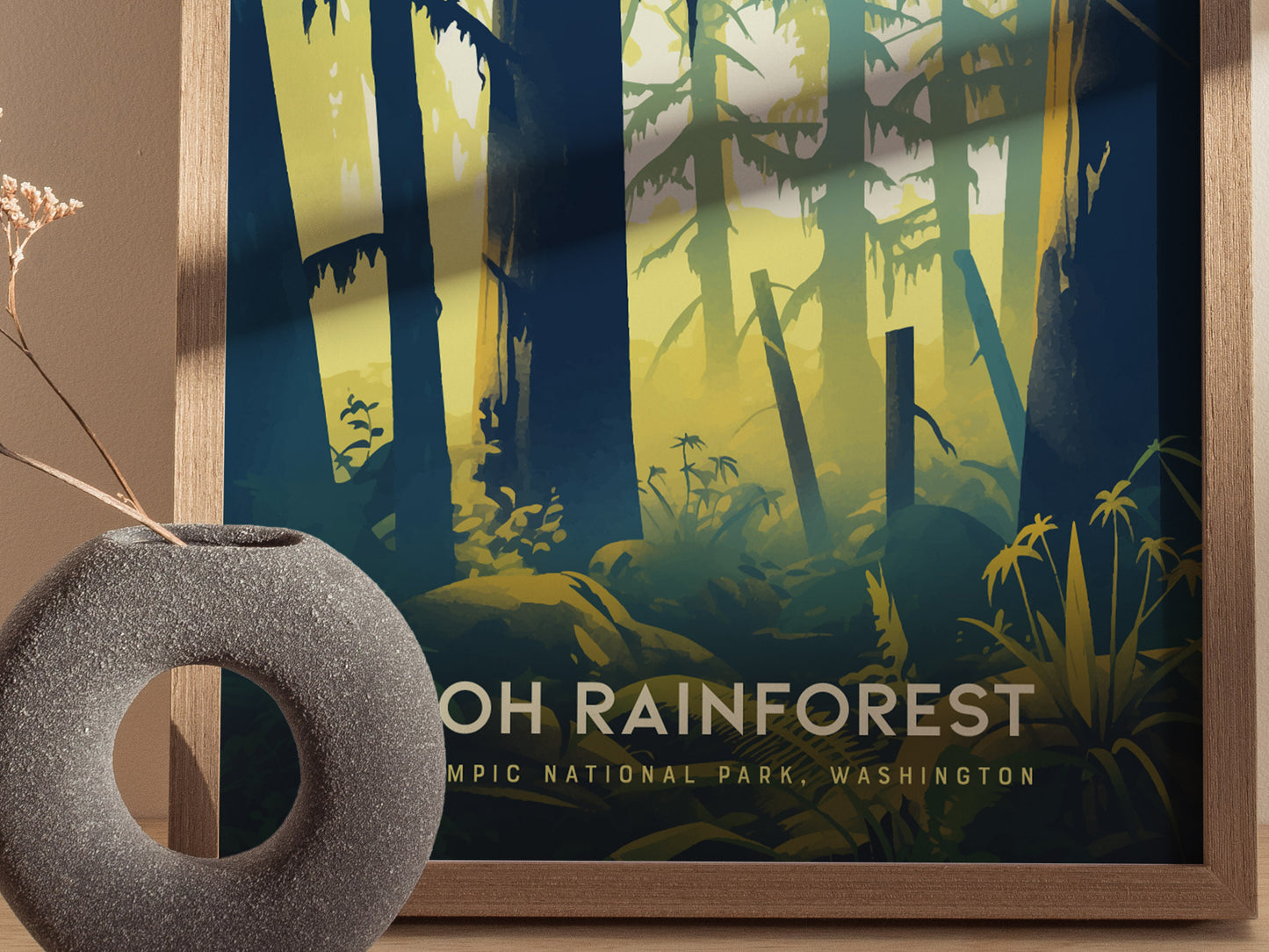 A framed poster of the Hoh Rainforest with stylized illustrations of trees and foliage is displayed next to a textured, round stone vase with dried flowers.