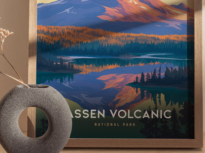 Framed poster of Lassen Volcanic National Park features vibrant, stylized mountains and forests reflected in a lake. A round stone vase with dried flowers sits nearby.