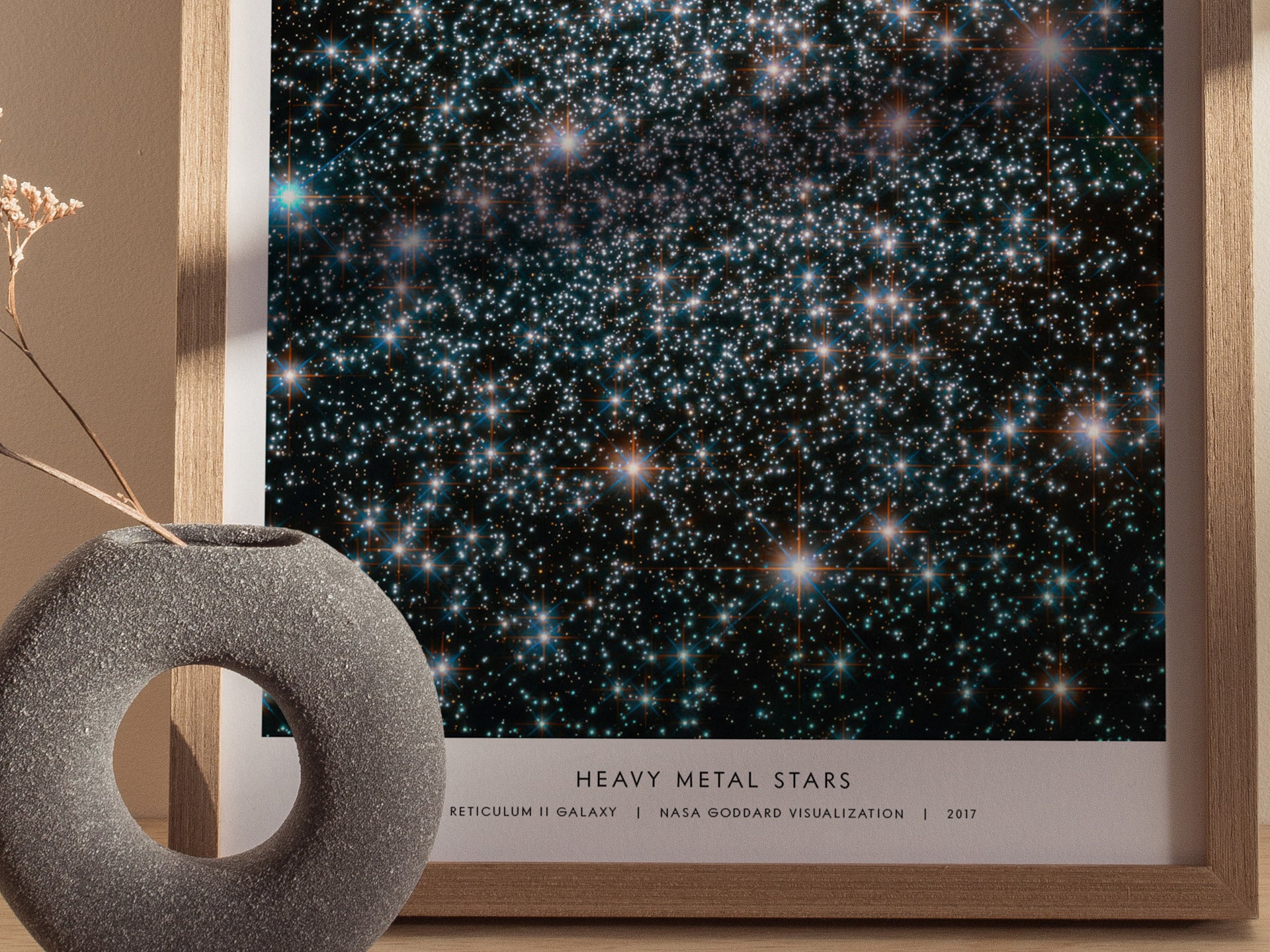 Framed poster of a starry night sky with 'Heavy Metal Stars' text, placed on a surface with a decorative object.