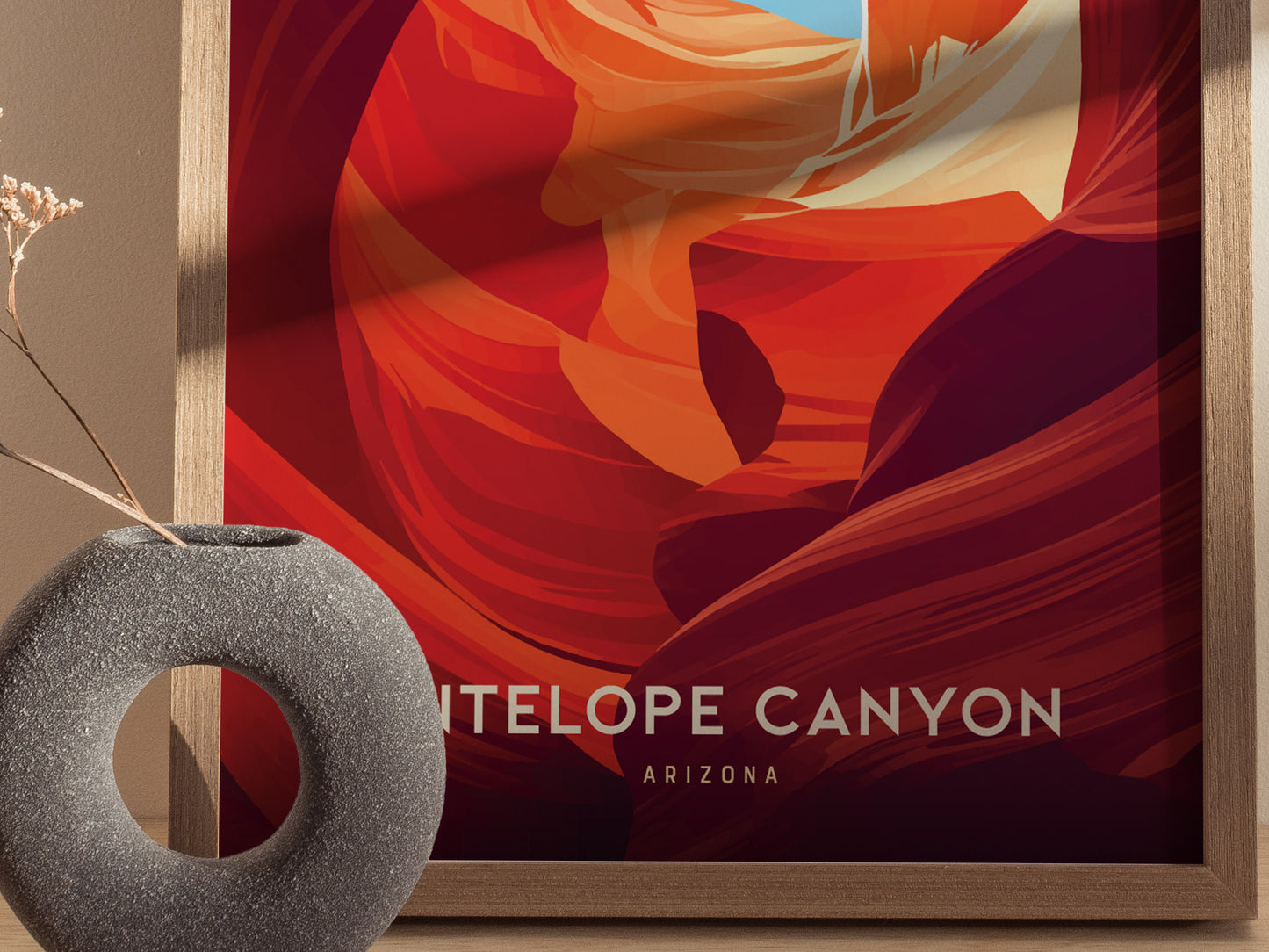 A framed Antelope Canyon poster with vibrant red and orange abstract designs is displayed next to a round, textured gray vase with dried flowers.