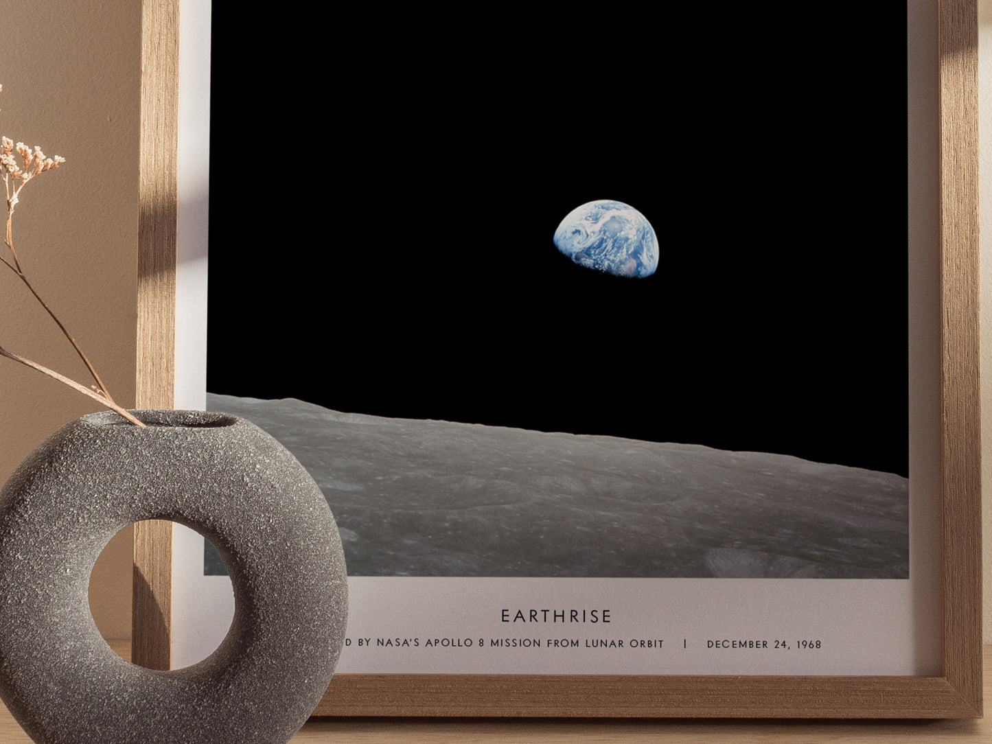 Framed photograph of Earthrise from the Moon with a decorative object in the foreground.