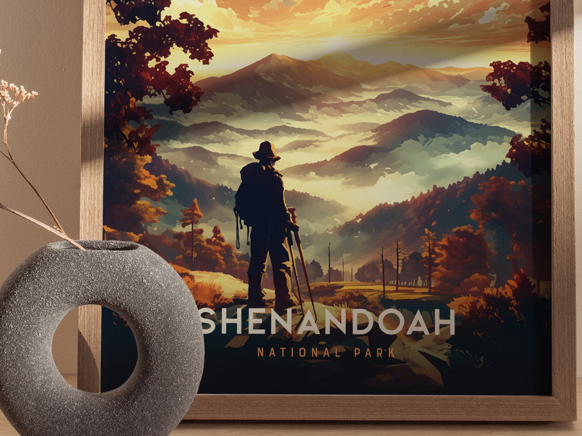 A framed poster of Shenandoah National Park shows a silhouetted hiker overlooking misty mountains and colorful autumn foliage, with Shenandoah National Park text. A round, gray vase is nearby.