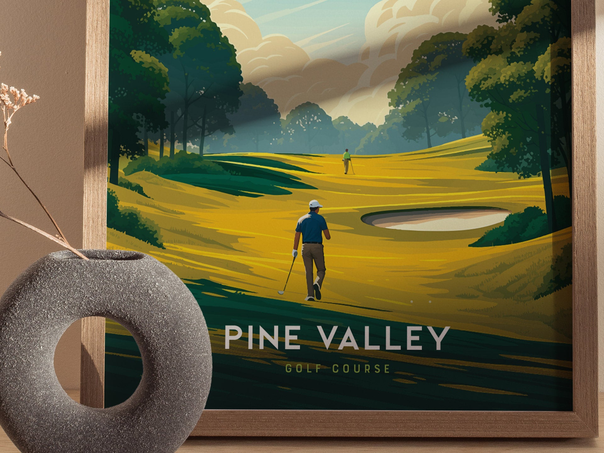 A framed poster of Pine Valley Golf Course shows two golfers on a vibrant, stylized fairway surrounded by lush trees, with a modern vase in the foreground.