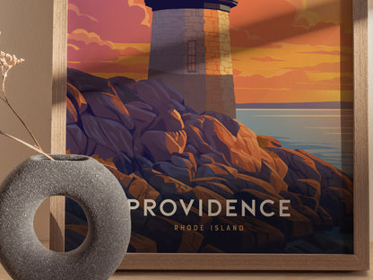 A framed poster depicts a lighthouse on rocky cliffs at sunset, with bold text reading Providence Rhode Island. A gray circular vase is placed nearby.