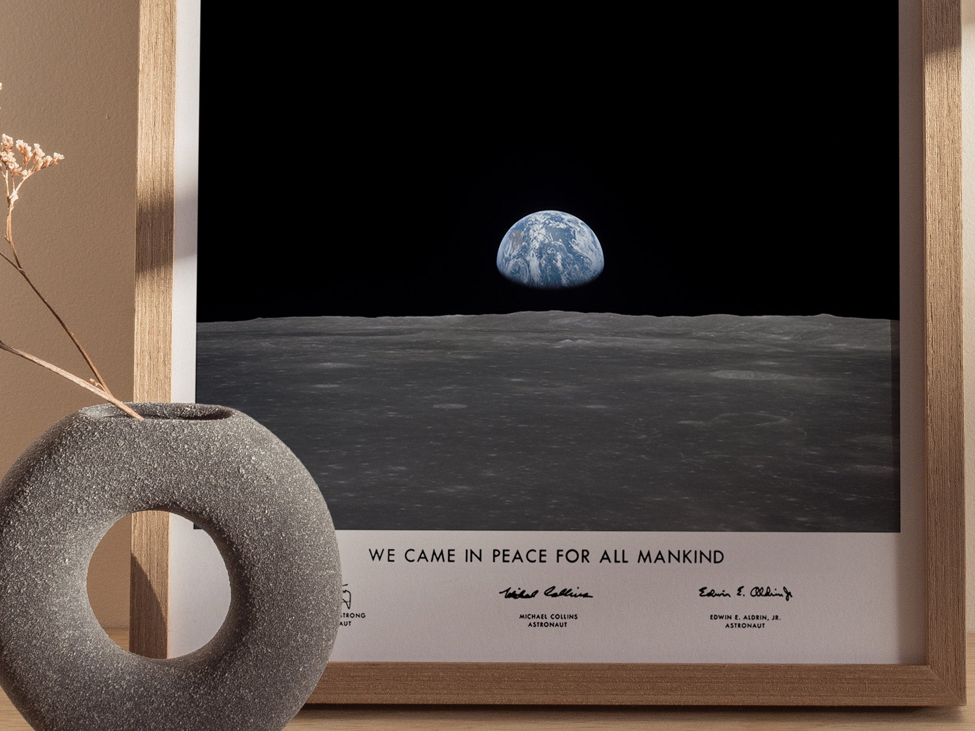 Close up of Apollo 11 Earth on the Horizon poster highlighting Earth, lunar horizon, and “We came in peace for all mankind” inscription