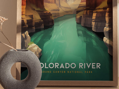 A framed poster of the Colorado River at the Grand Canyon features vivid green waters and rugged canyon walls. A textured circular vase with dried flowers is in the foreground.