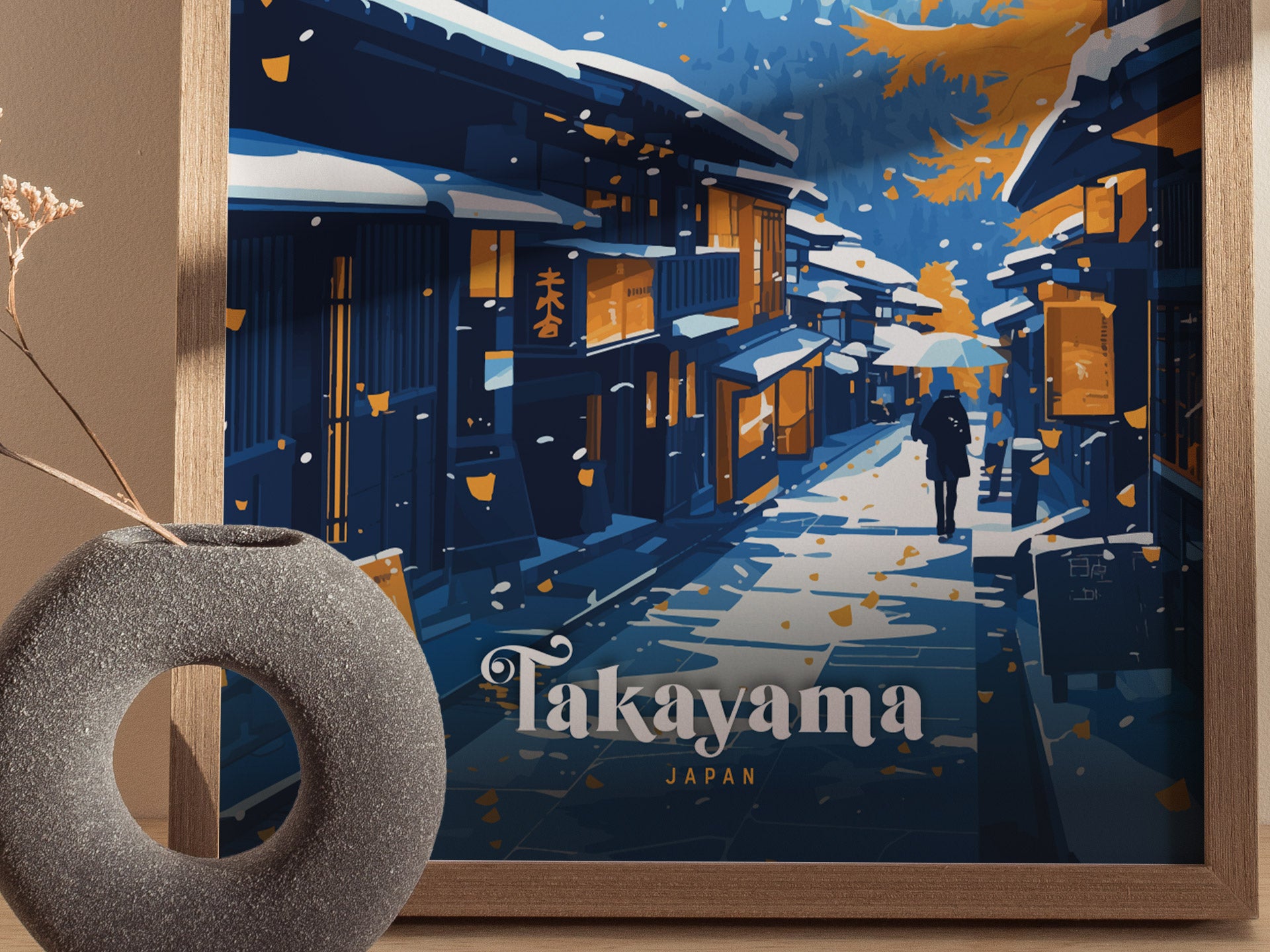A framed poster depicts a snowy street in Takayama, Japan, with traditional wooden houses. A person walks with an umbrella, surrounded by falling leaves. A round vase is visible nearby.