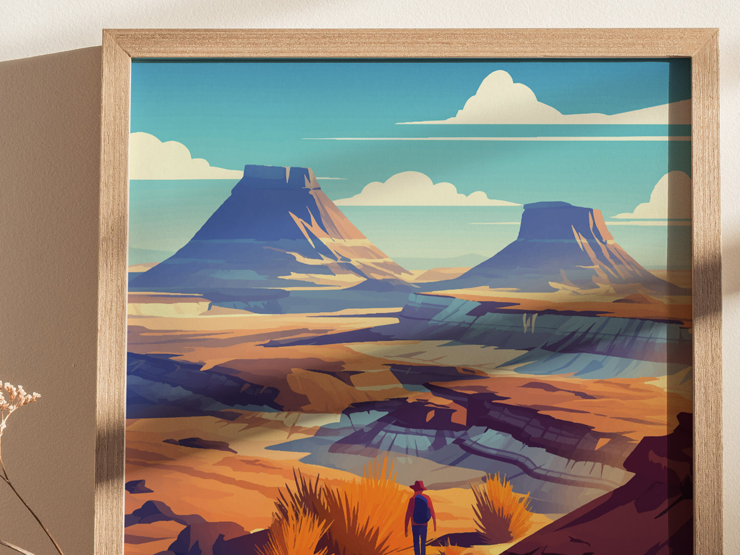 A framed art print depicts a vibrant desert landscape with colorful mesas and a lone figure in the foreground. The sky is blue with scattered clouds, enhancing the scenes tranquility.