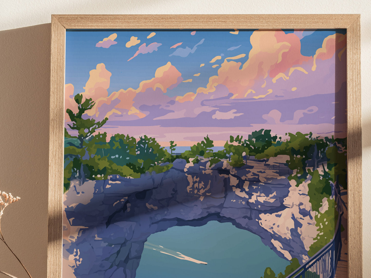 A framed illustration featuring Mackinac Islands Arch Rock with lush greenery, rugged cliffs, and a vibrant sunset sky in pink.