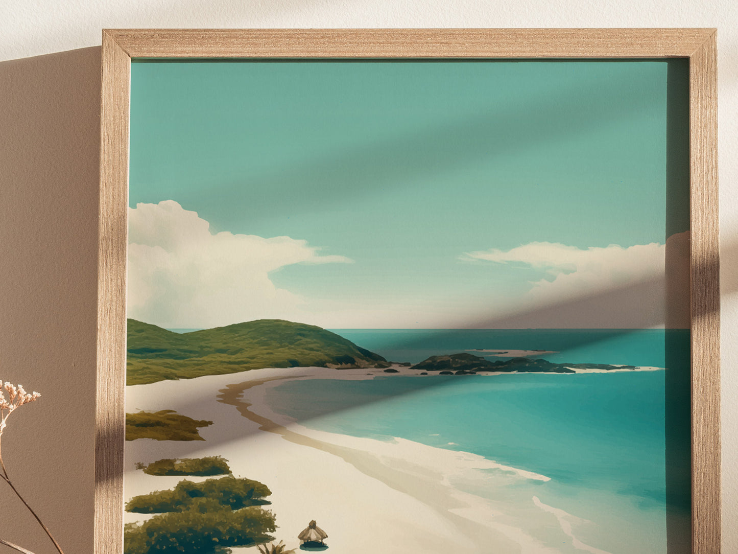 A framed art print depicts a serene tropical beach with turquoise waters, white sand, and lush green hills under a clear blue sky. Shadow falls across the image.