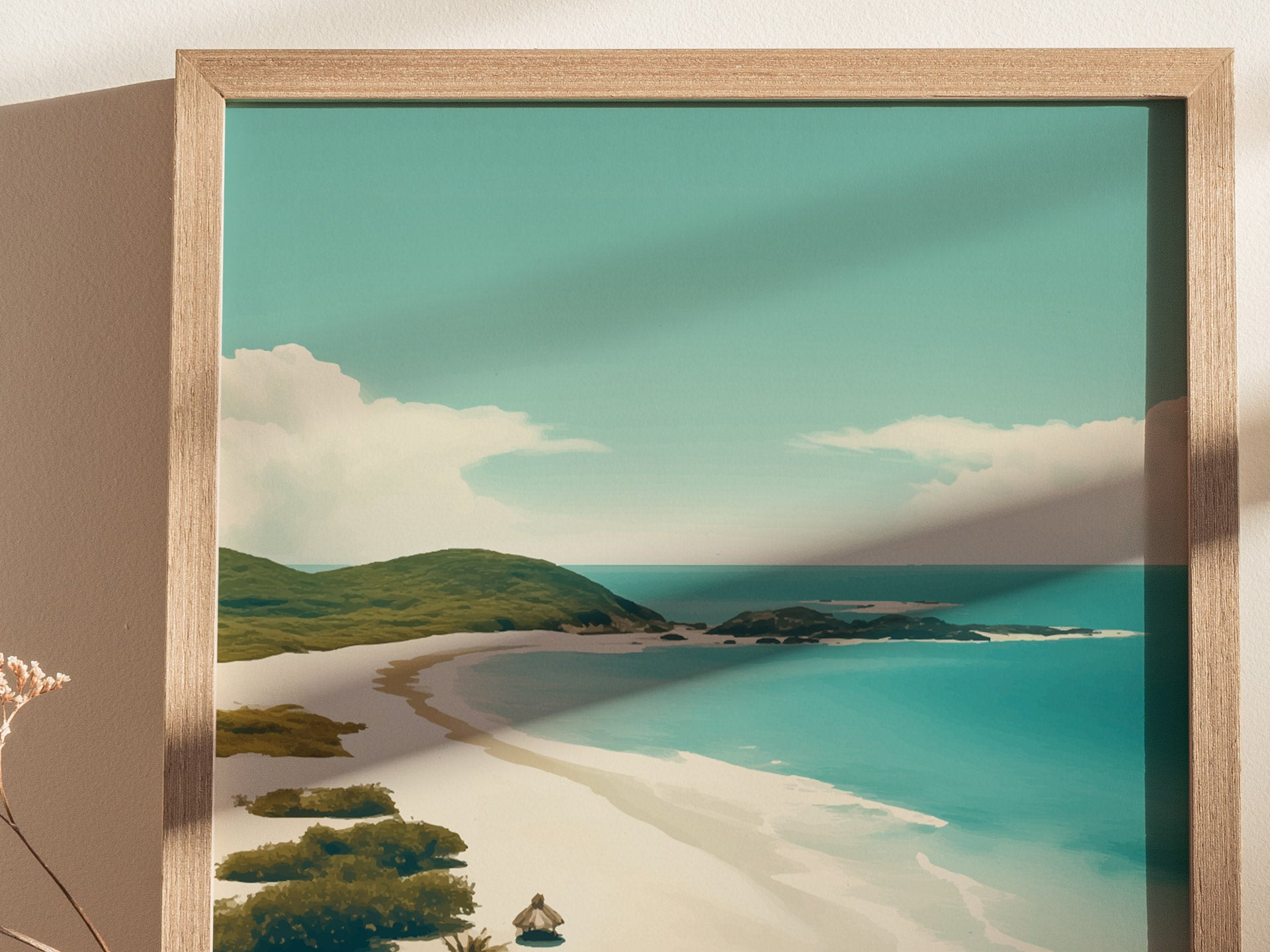 A framed art print depicts a serene tropical beach with turquoise waters, white sand, and lush green hills under a clear blue sky. Shadow falls across the image.