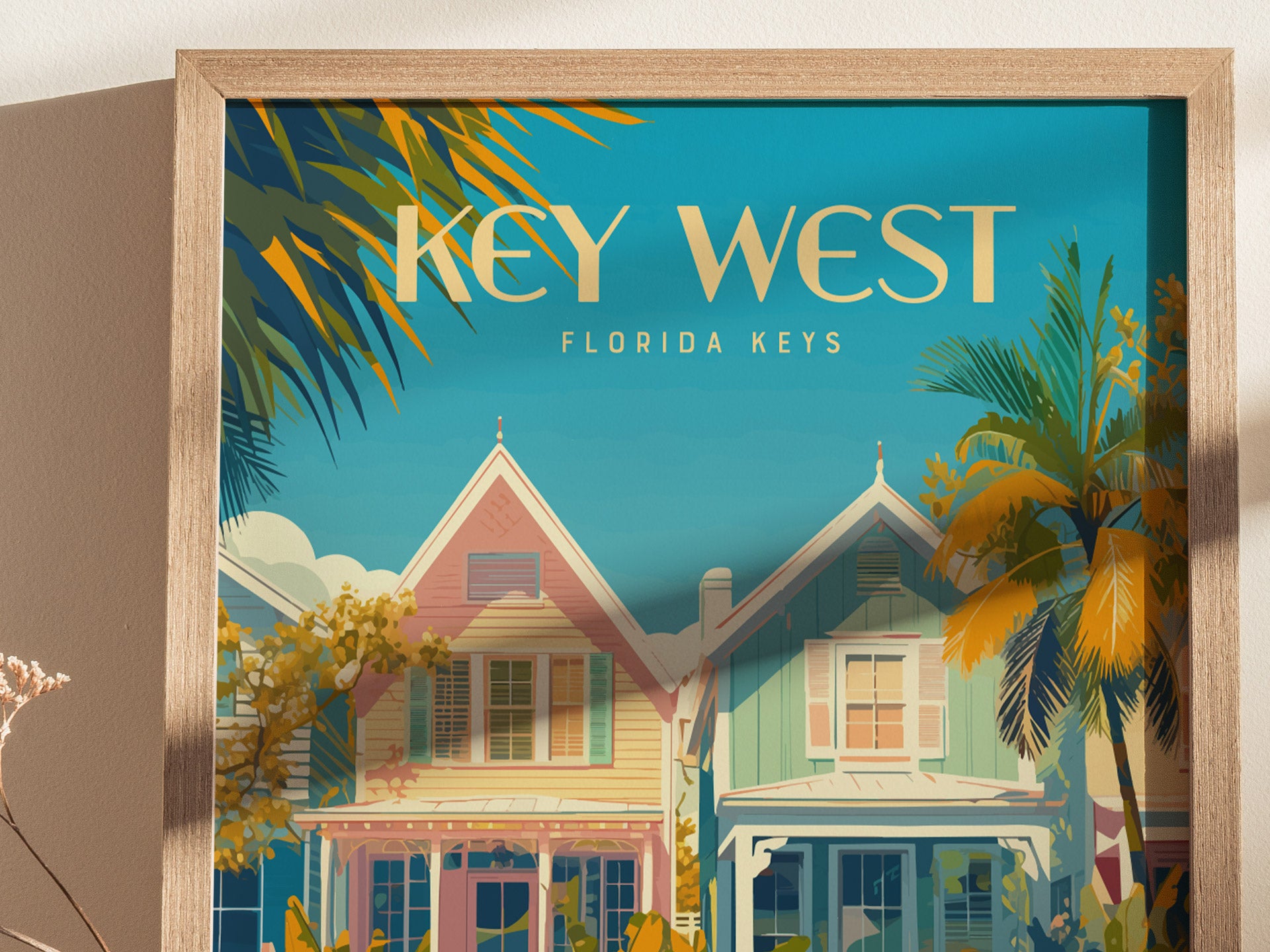 Framed artwork depicting pastel-colored houses and palm trees under a clear blue sky, with Key West Florida Keys text. The vibrant scene captures the essence of tropical island life.