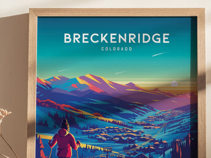 A colorful poster depicts a skier overlooking Breckenridge, Colorado, with vibrant mountains and a sunset sky in the background, framed in light wood.
