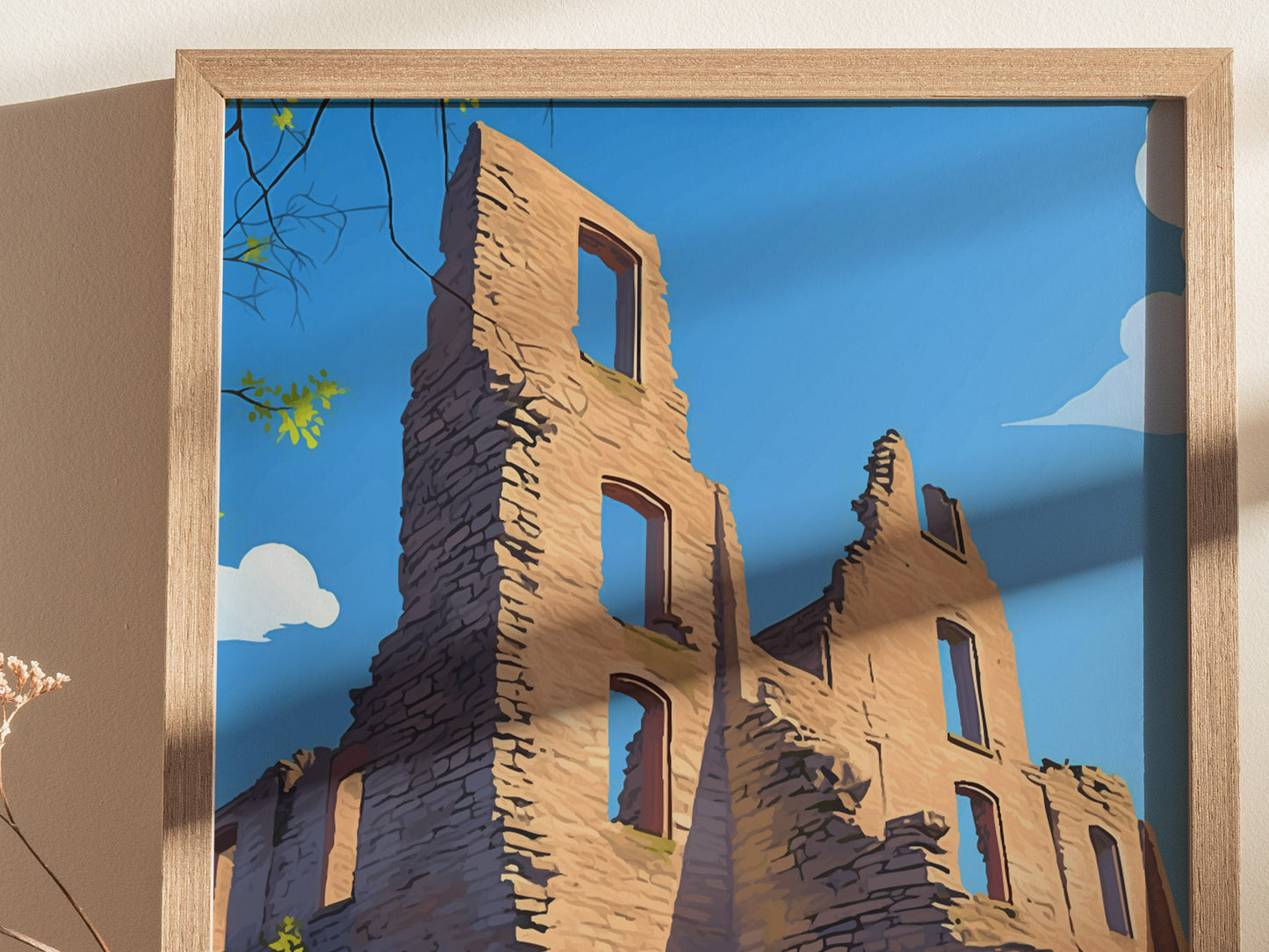 A framed artwork depicts the ruins of a stone building against a clear blue sky. Sunlight casts shadows, and some green leaves are visible in the top left corner.