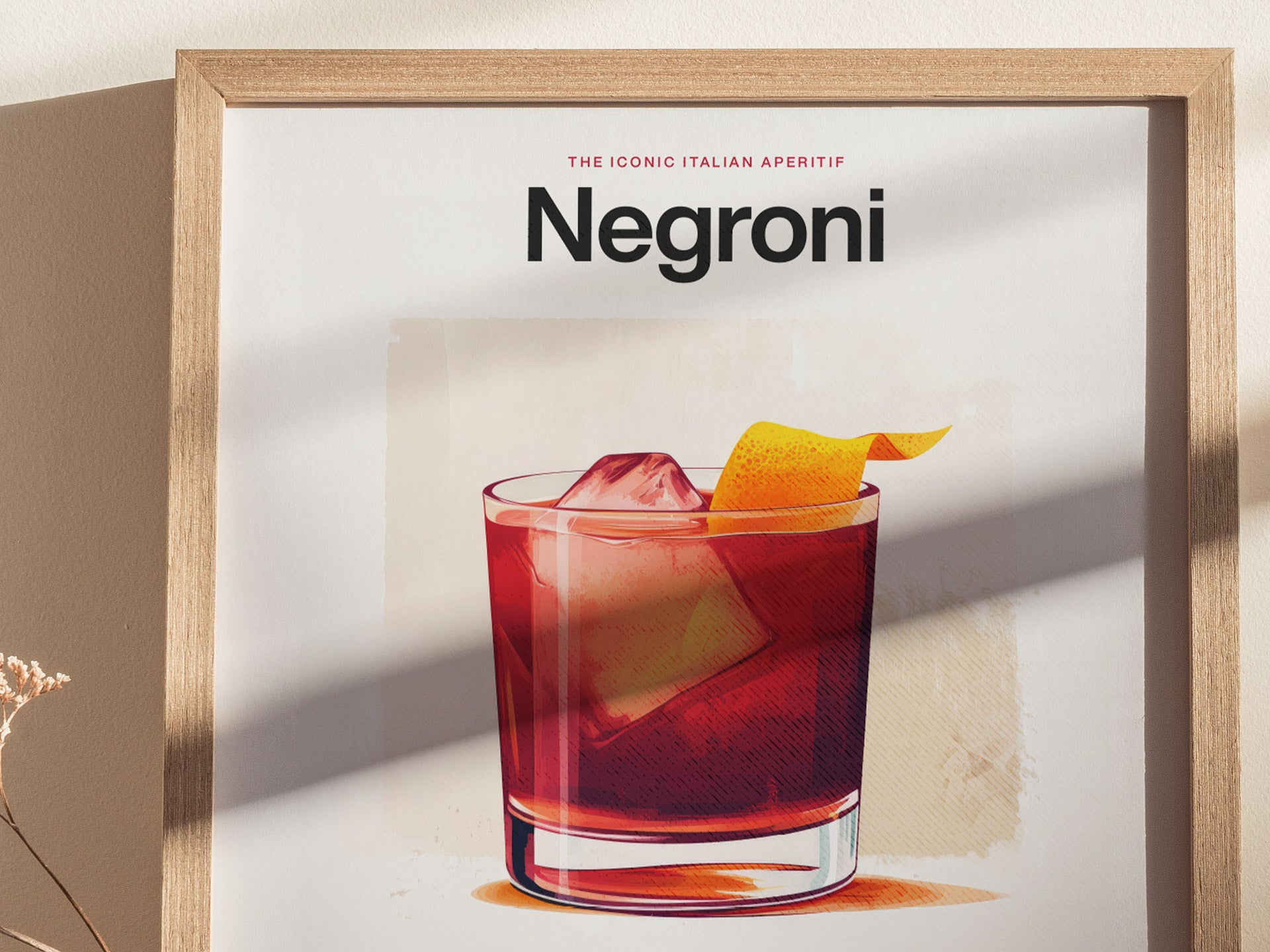 A framed Negroni cocktail poster features a vibrant illustration of the drink with an orange peel garnish, set against a minimalist background. Soft shadows add depth to the scene.