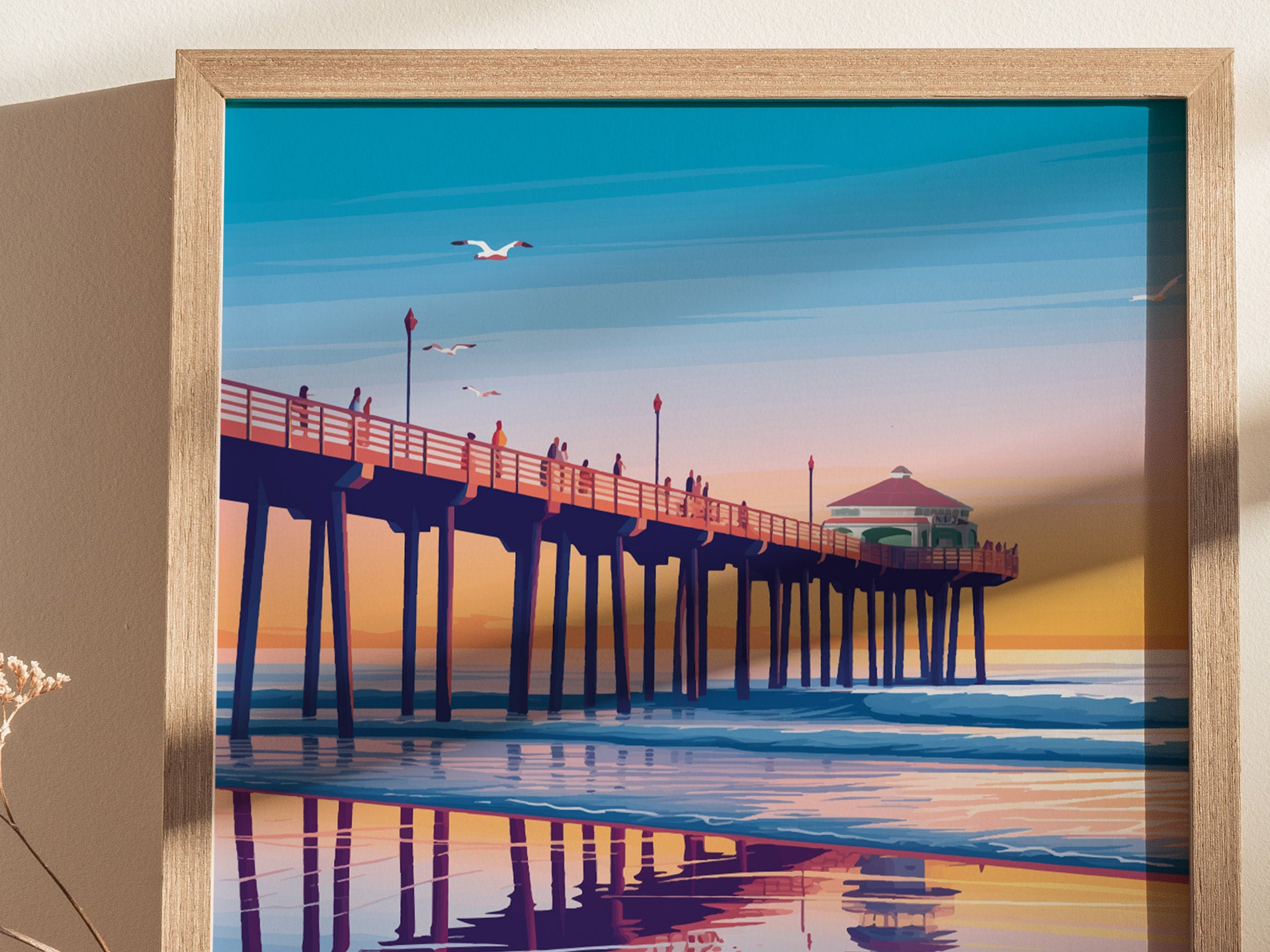 Framed poster of Huntington Beach Pier at sunset, featuring vibrant colors and seagulls in the sky, with reflections on the water below.