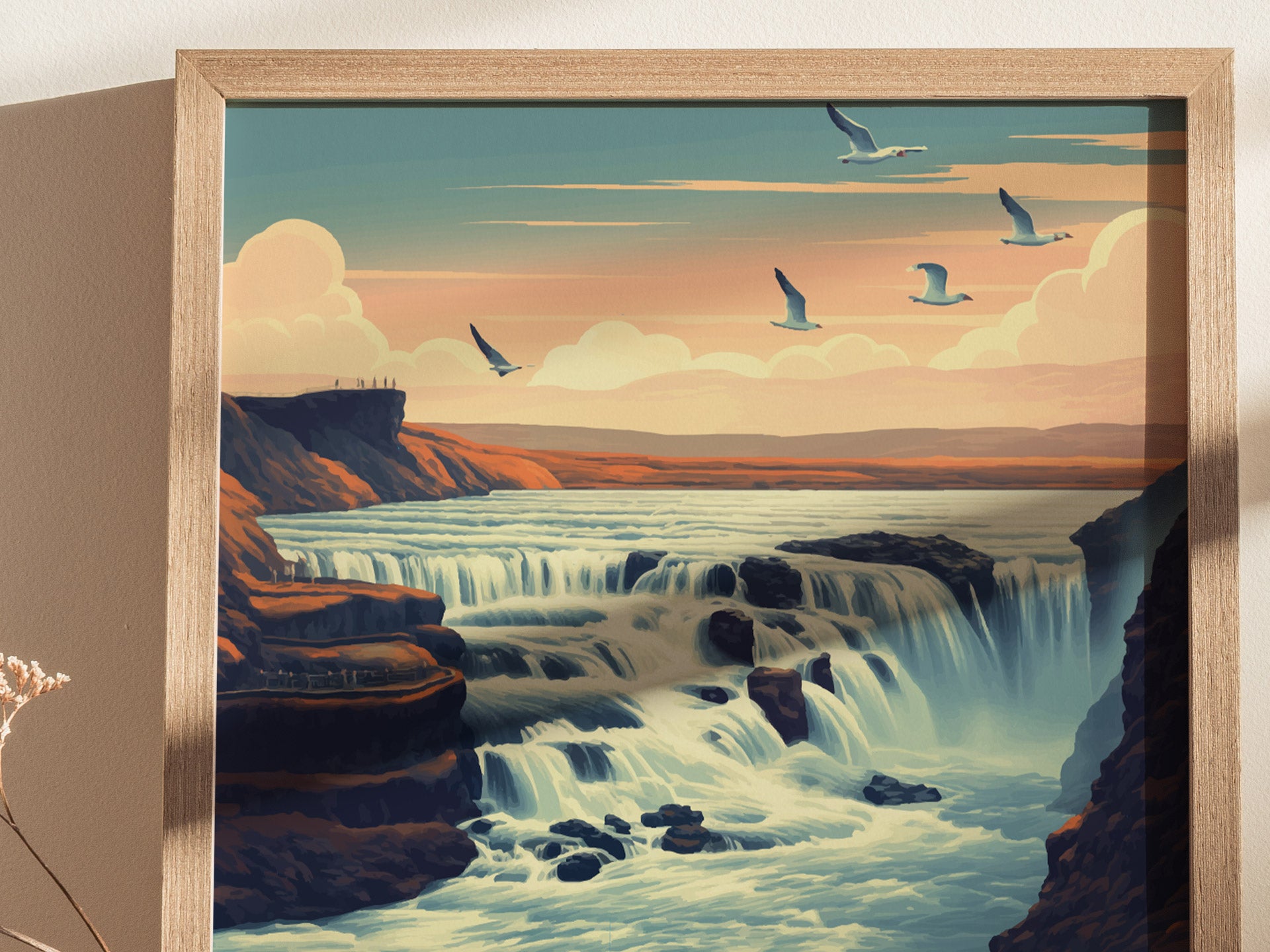 A framed poster depicts a stylized waterfall with cascading water, set against a sunset sky with flying birds. The landscape features rugged cliffs and distant figures on a viewpoint.