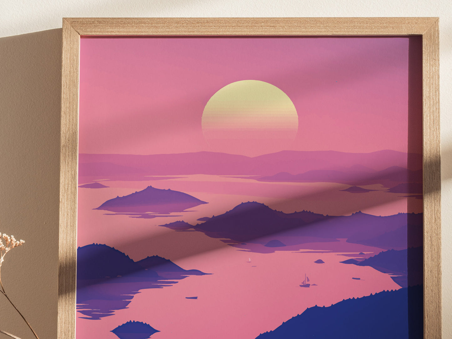 A framed poster depicts a stylized sunset over island silhouettes with pink and purple hues. The serene scene includes small sailboats on the calm water, creating a tranquil atmosphere.