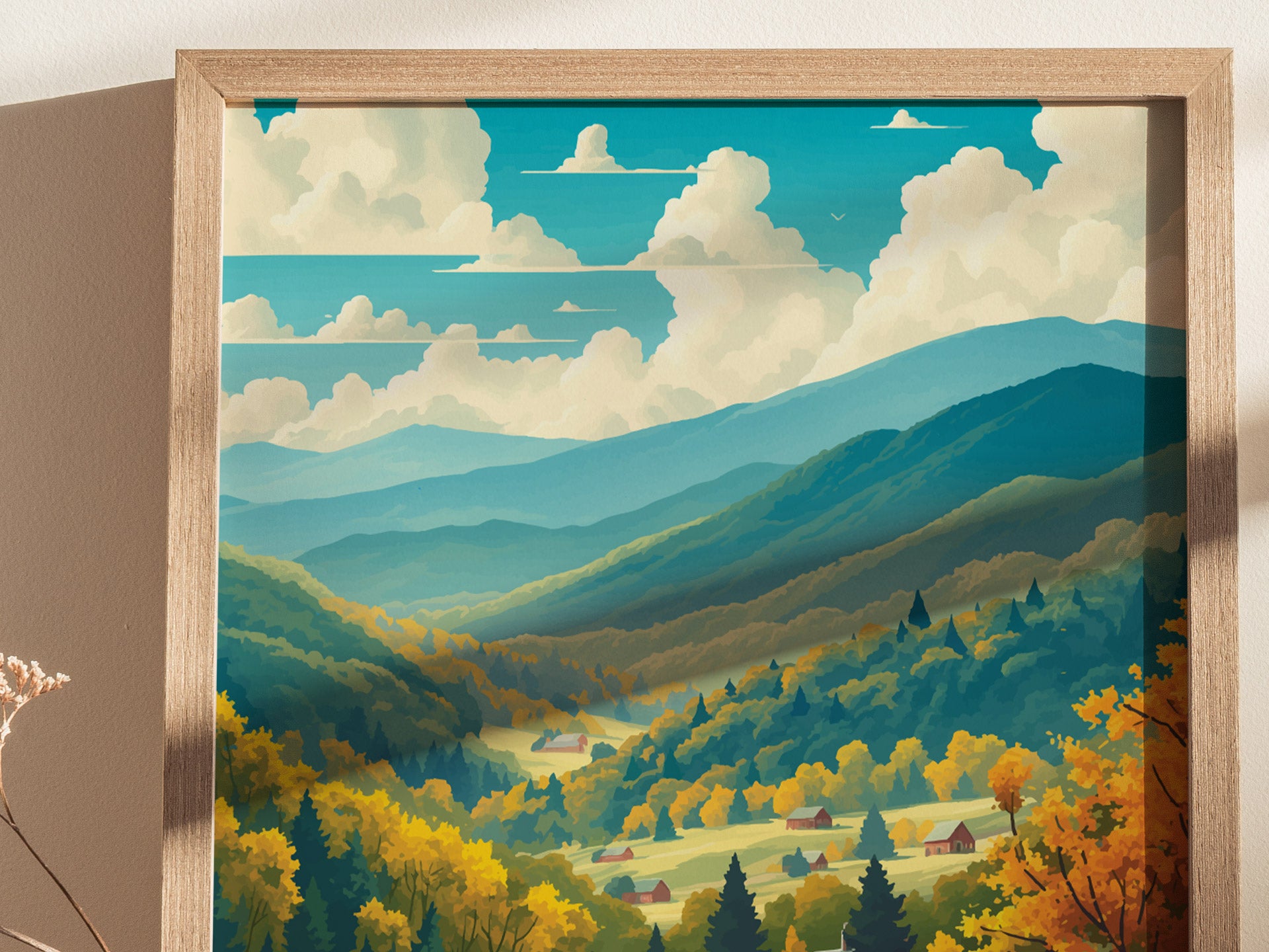 A framed poster depicts a scenic view of lush green and yellow forests, rolling hills, and mountains under a sky with fluffy clouds. Small houses are nestled in the valley.