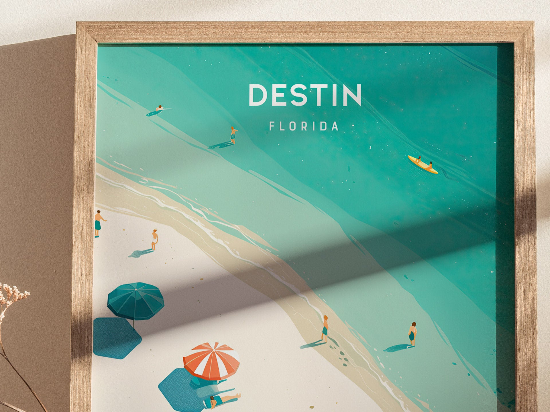 A framed poster depicts a serene beach scene with turquoise waters, soft white sand, colorful beach umbrellas, and people enjoying the shoreline. The text reads Destin Florida.